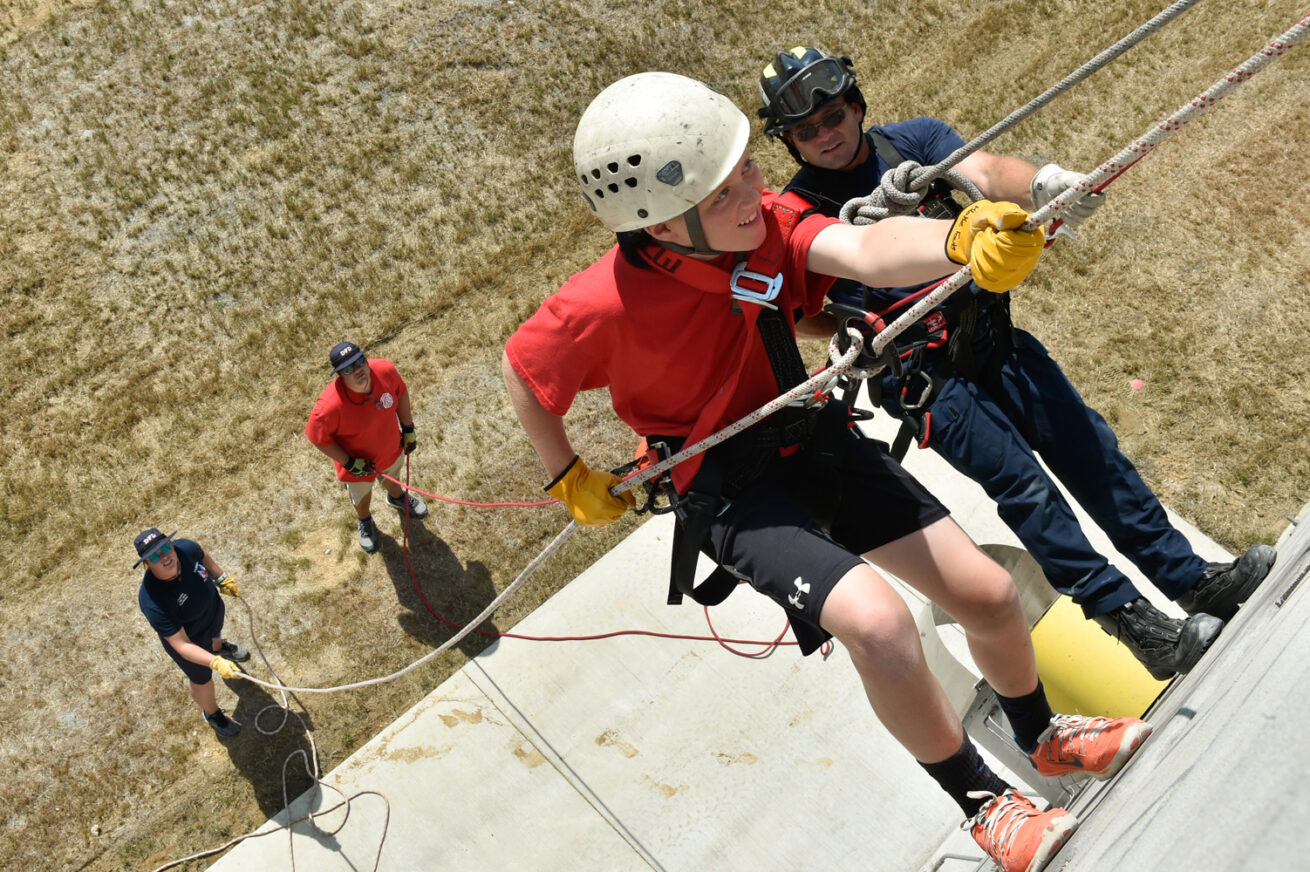 Camp student Blake Fouts, left, repels down a wall with assistance from Denton firefighter Vance Bowden during Fire Camp at Denton City Fire Station 7, Friday, June 21, 2019, in Argyle, Texas.  The camp focuses on teamwork and problem solving in a controlled environment, while providing insight to the Fire Service. The students will learn a wide range of skills from CPR, rappelling and firefighting.
